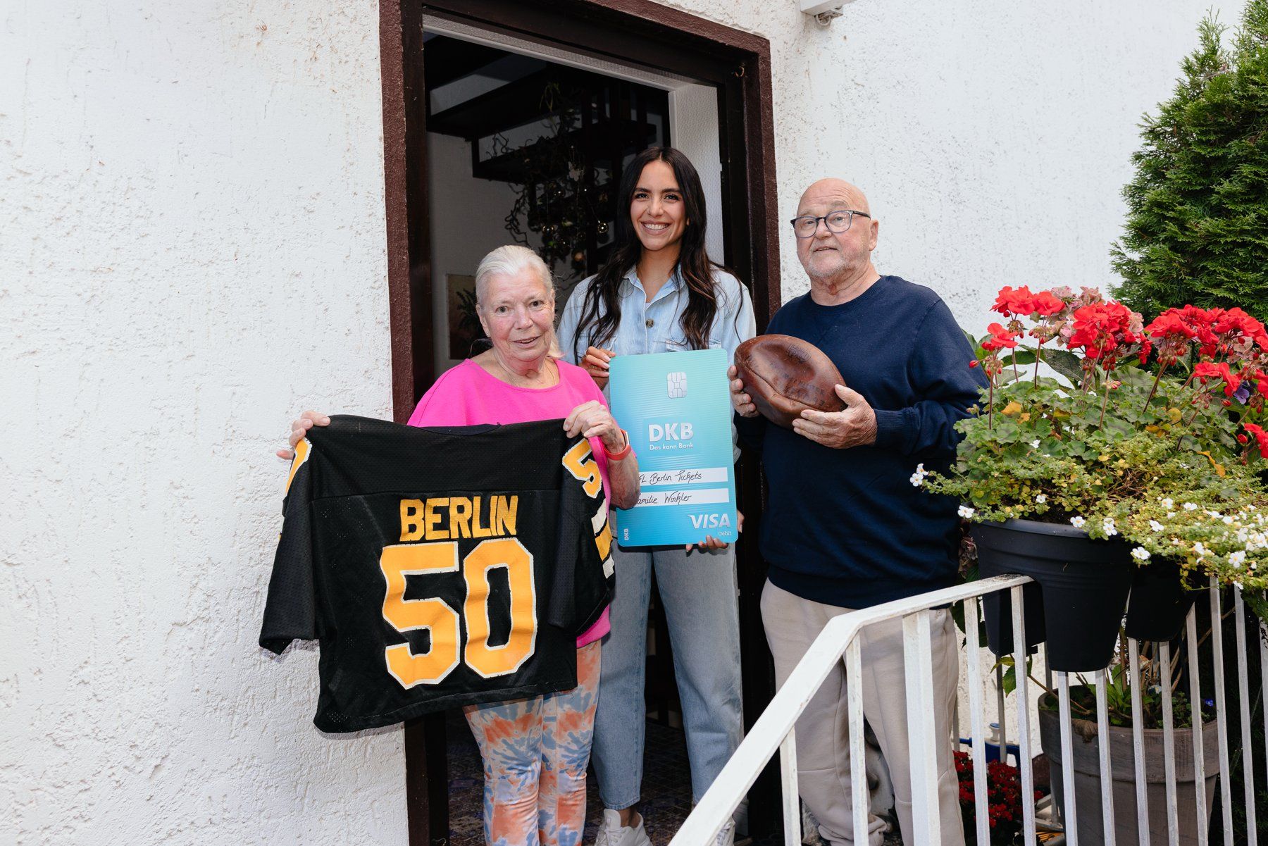 Langjähriges Football-Paar mit Berlin-Trikot und DKB-Ticketkarte vor dem Haus